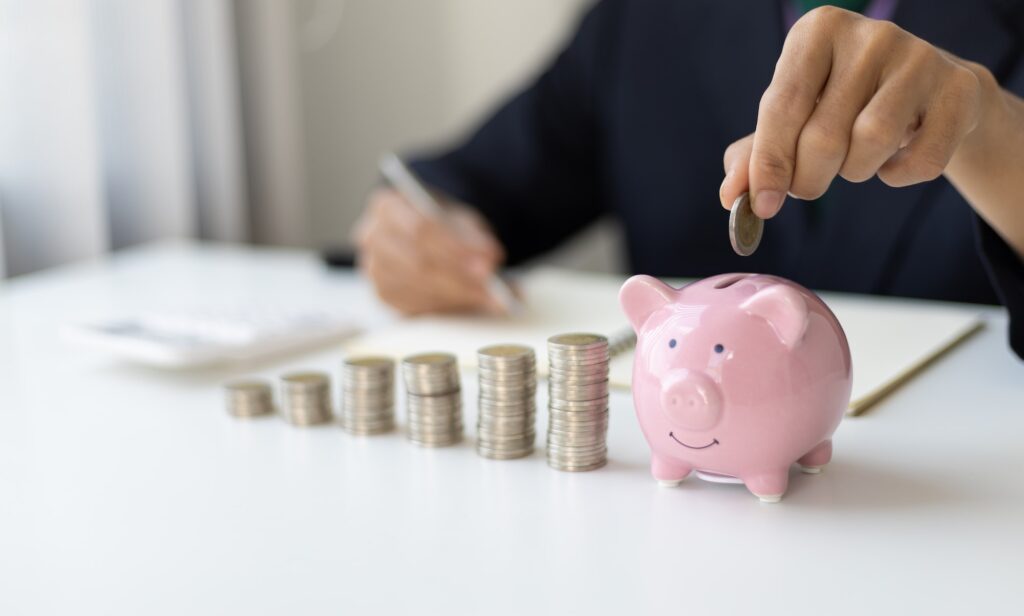 Retirement Savings and Financial Planning Concept. Businessman putting coin into piggy bank.